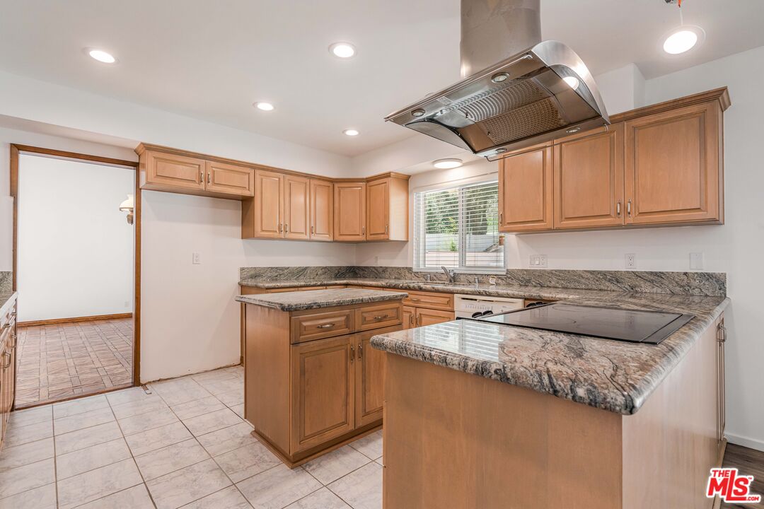 1181 Somera Road Los Angeles, CA 90077 - Photo 11 of 40 a kitchen with stainless steel appliances granite countertop a sink a stove a refrigerator and island