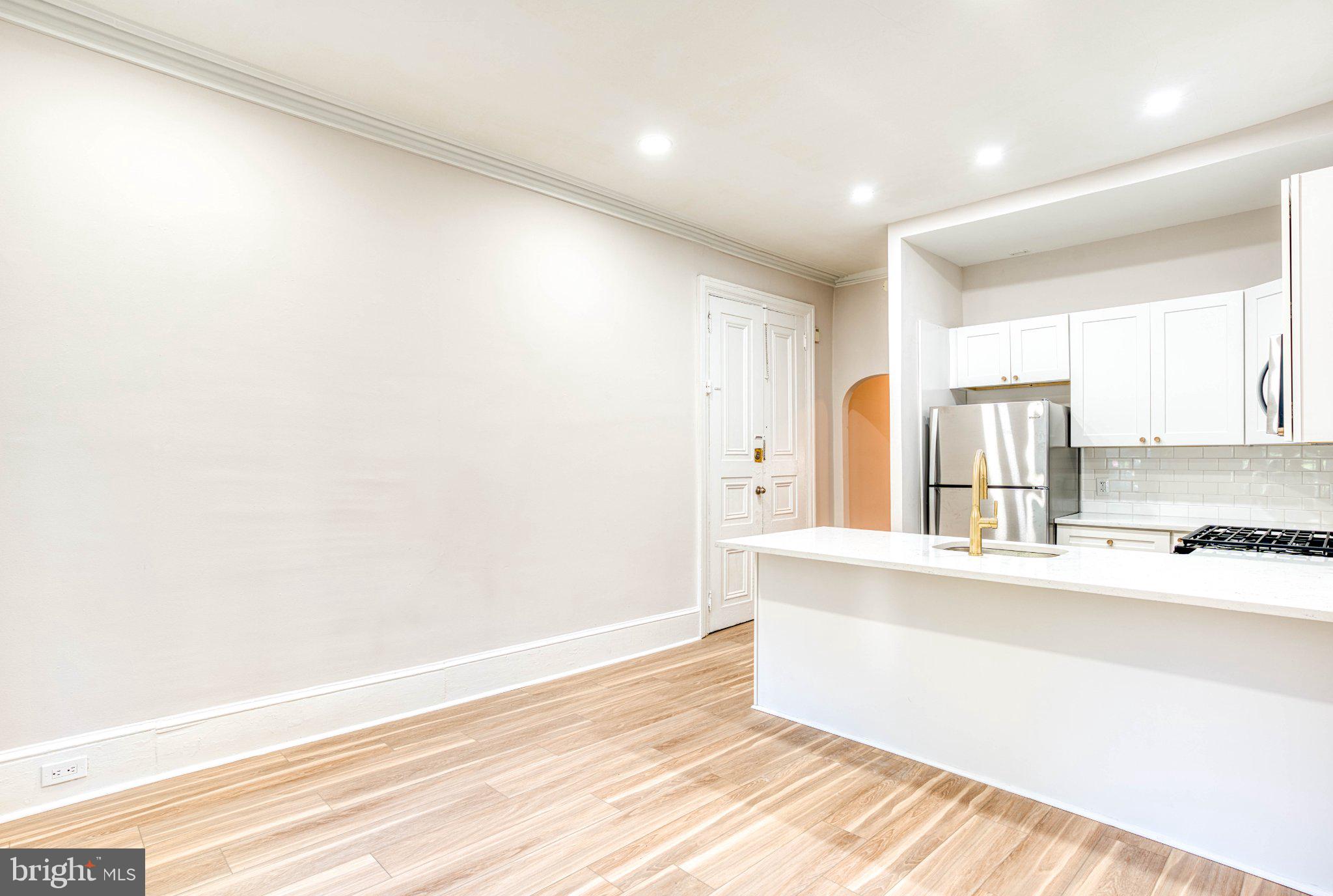 307 Kings Highway East, Unit 2 Haddonfield, NJ 08033 - Photo 11 of 21 a view of a kitchen with kitchen island a sink wooden floor and a large window