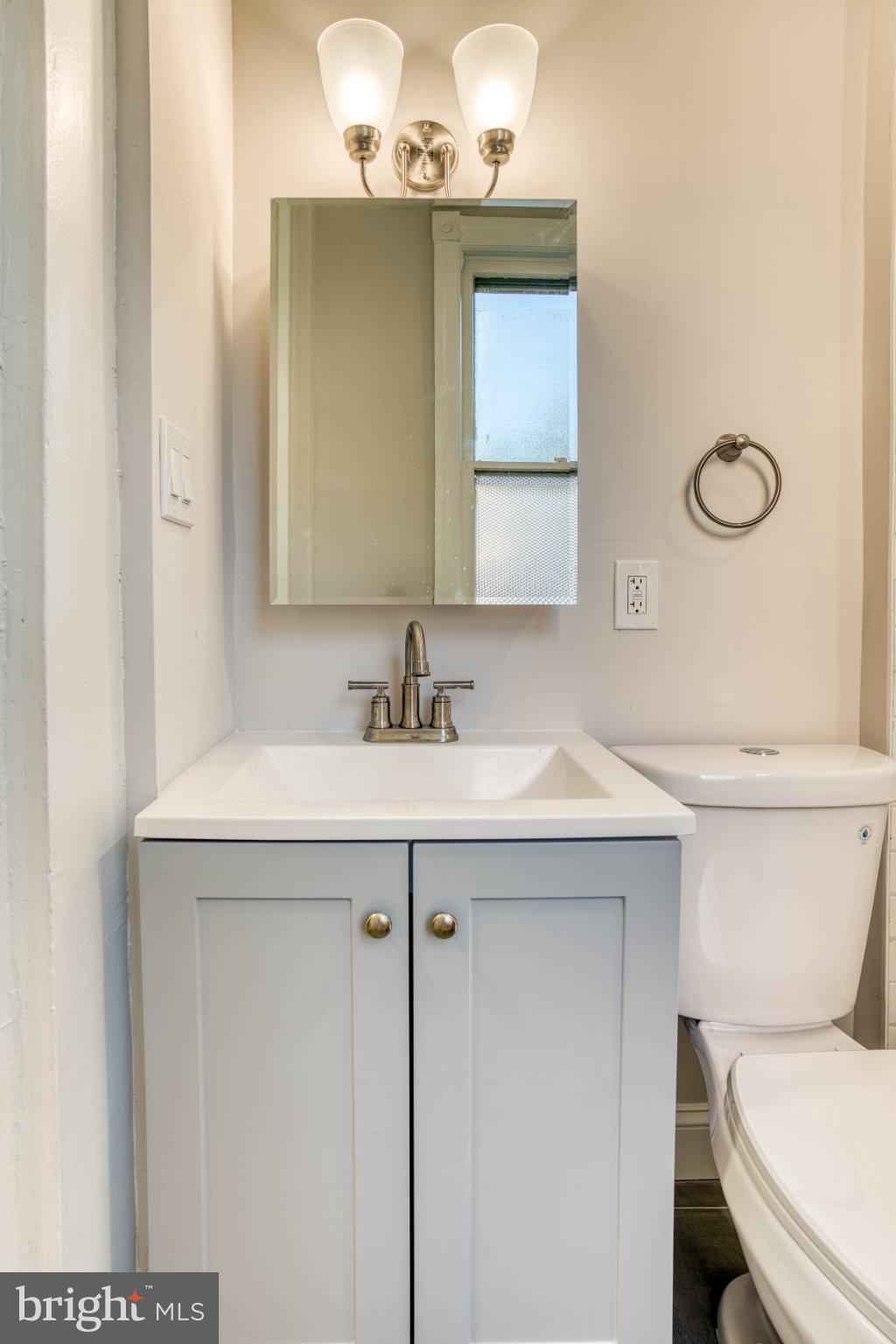 307 Kings Highway East, Unit 2 Haddonfield, NJ 08033 - Photo 14 of 21 a bathroom with a sink a toilet a mirror and vanity