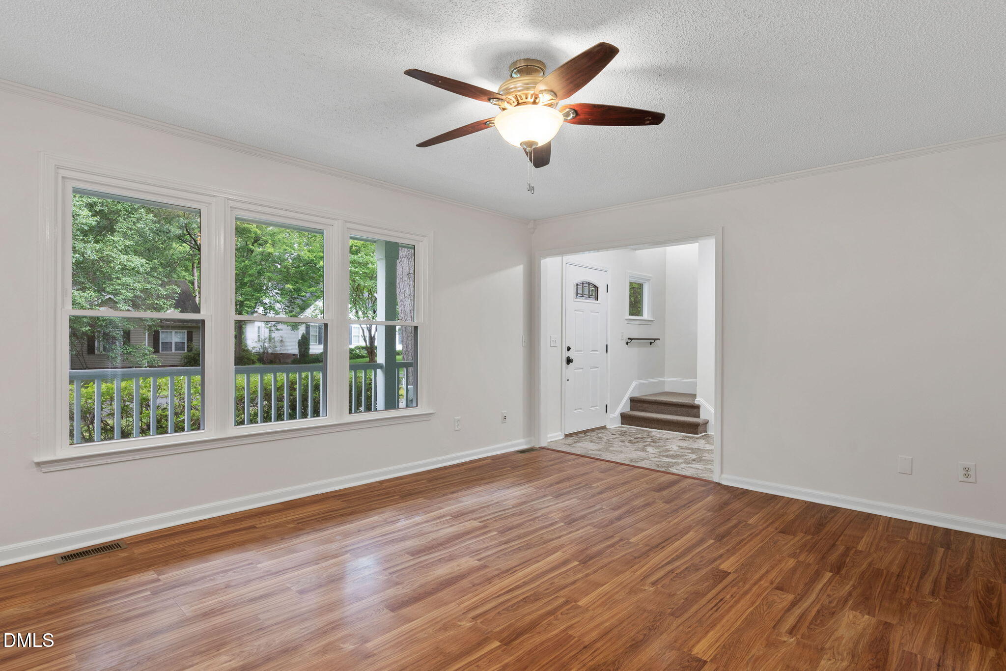 2724 Glastonbury Road Apex, NC 27539 - Photo 14 of 50 a view of an empty room with wooden floor and a window
