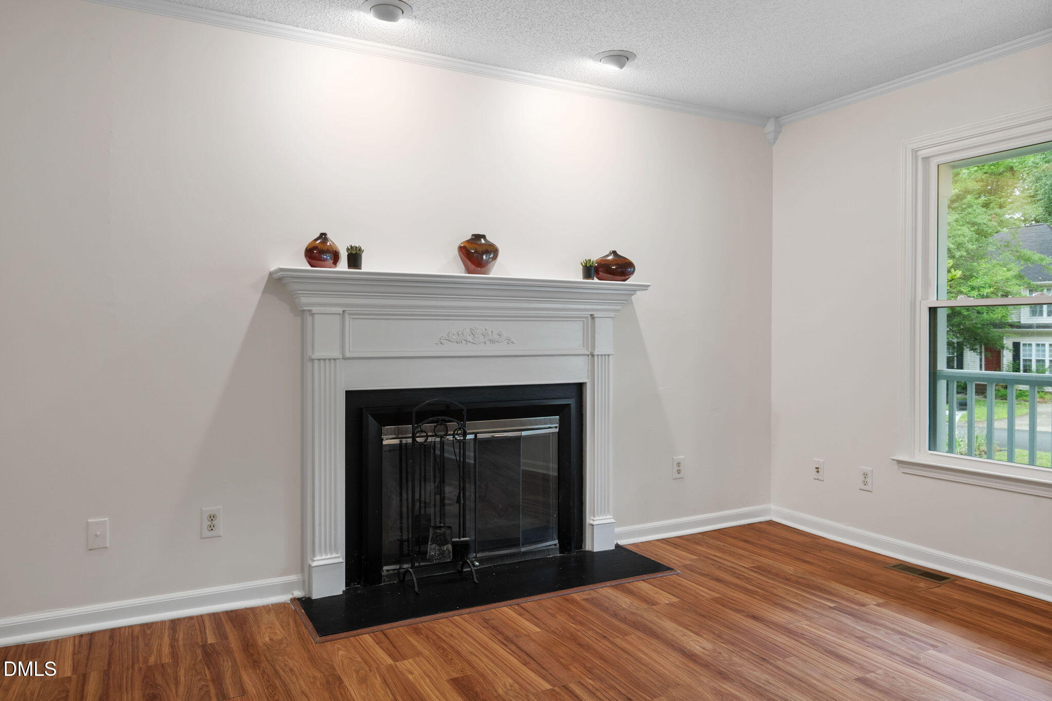 2724 Glastonbury Road Apex, NC 27539 - Photo 15 of 50 a view of an empty room with wooden floor and a fireplace