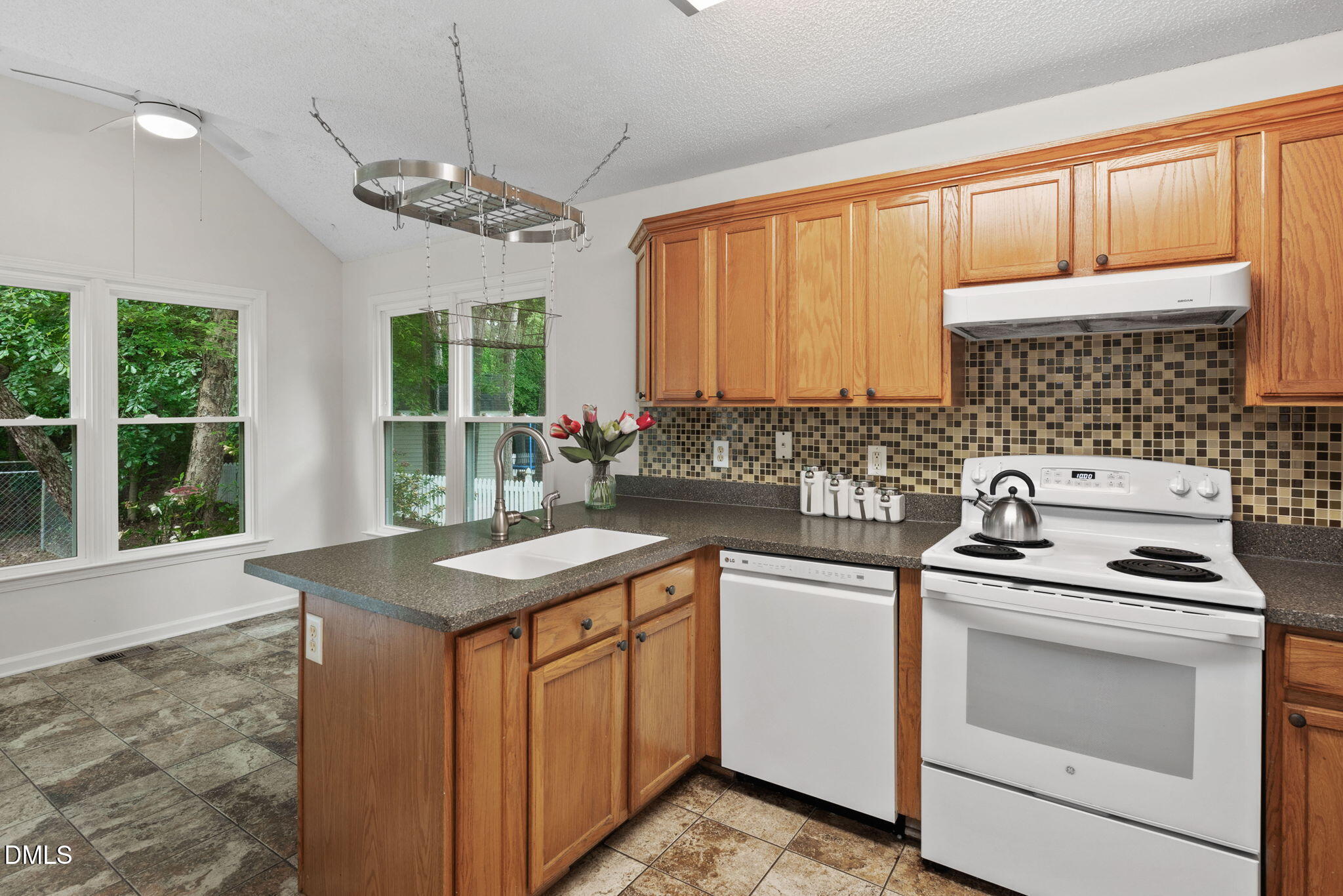 2724 Glastonbury Road Apex, NC 27539 - Photo 16 of 50 a kitchen with stainless steel appliances granite countertop a stove a sink dishwasher and microwave with wooden floor