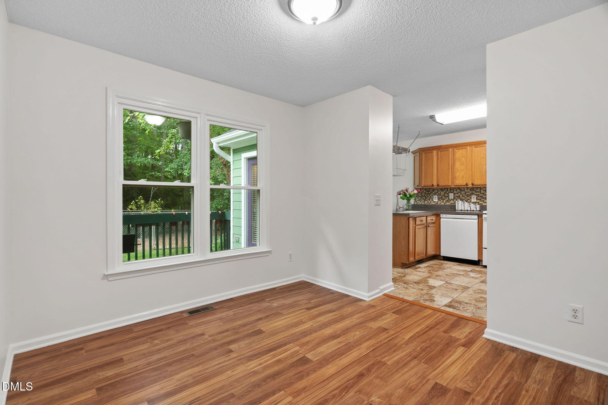 2724 Glastonbury Road Apex, NC 27539 - Photo 23 of 50 an empty room with wooden floor cabinet and windows