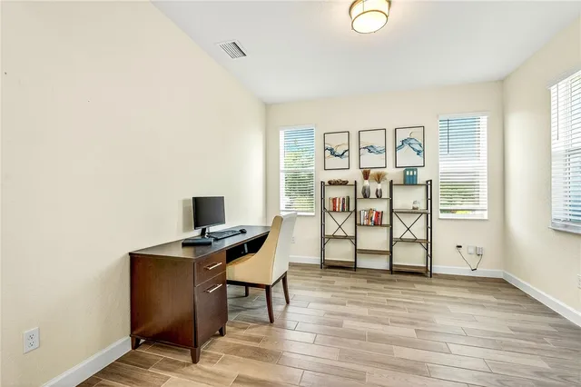 a view of a workspace with furniture and a window