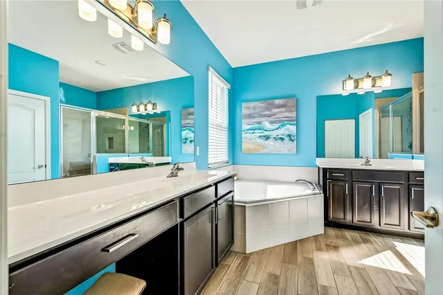 a bathroom with a tub sink and mirror
