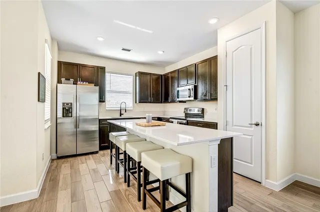 a kitchen with refrigerator cabinets and wooden floor