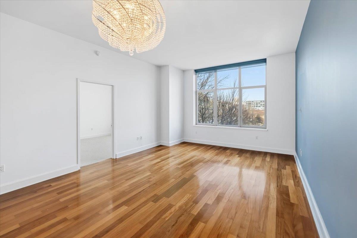 8100 River Road, Unit 209 North Bergen, NJ 07047 - Photo 9 of 42 an empty room with wooden floor and windows