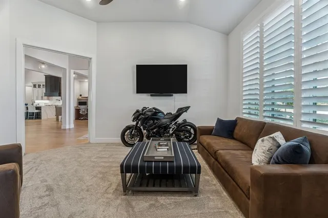 a living room with furniture a flat screen tv and a large window
