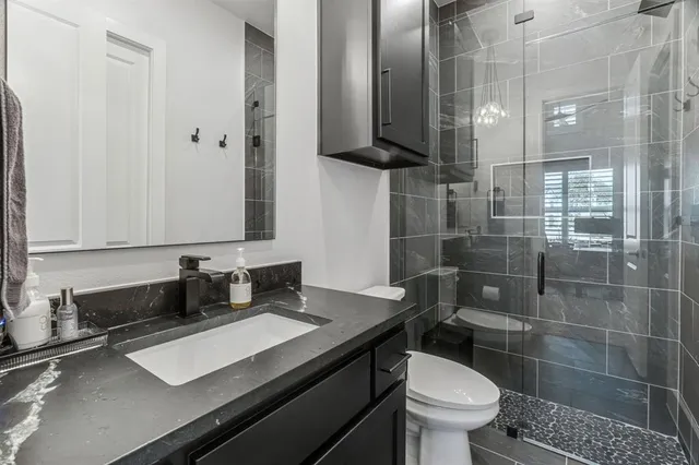 a bathroom with a sink a toilet and shower