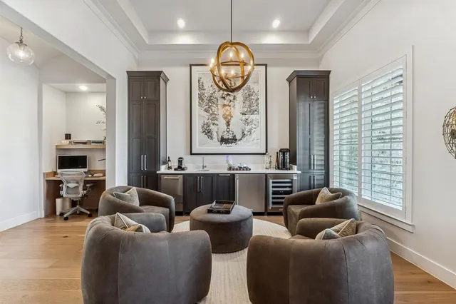 a living room with furniture a chandelier and a large window