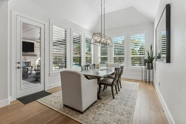 a dining room with furniture a chandelier and wooden floor