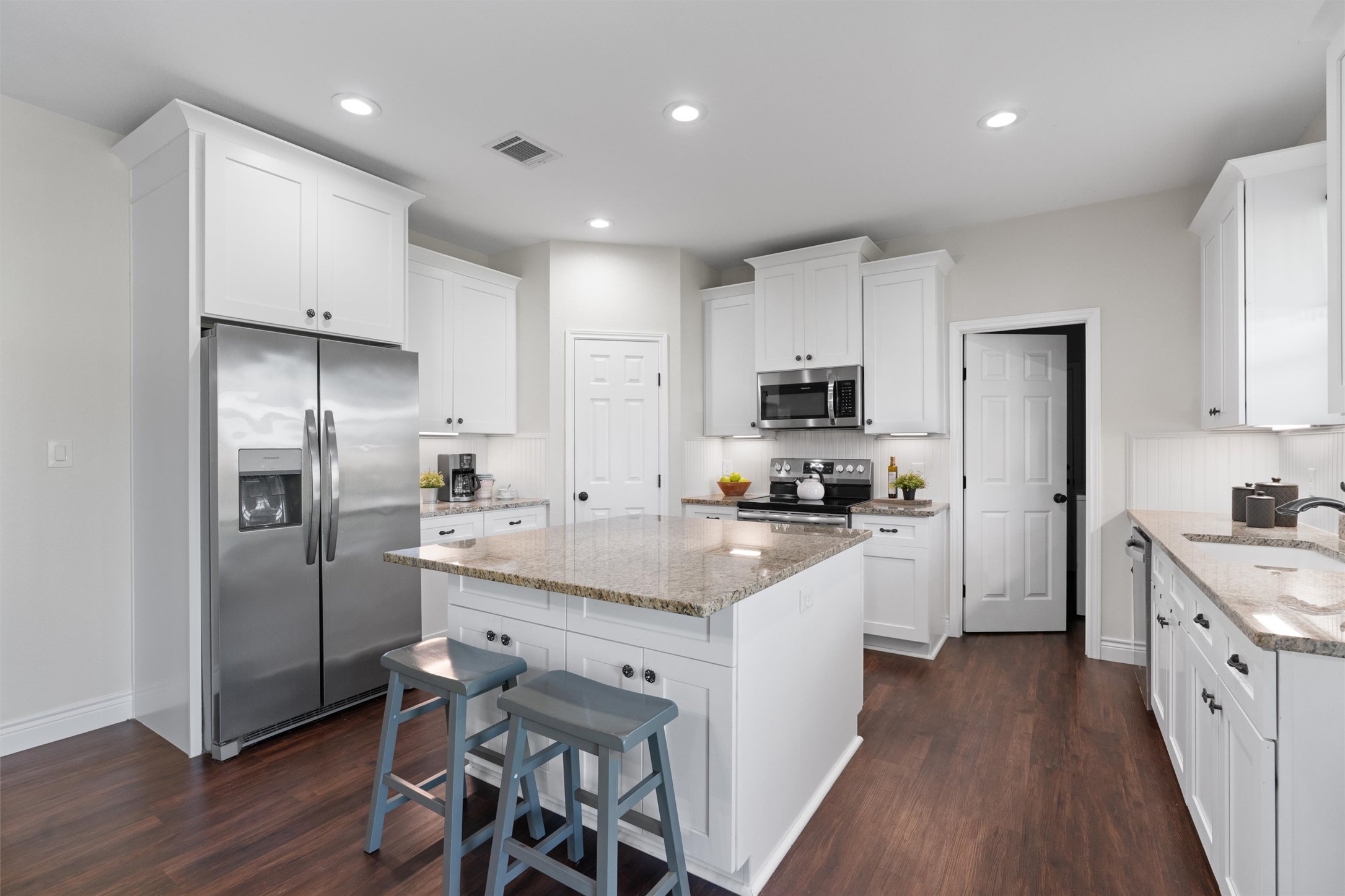 4651 Fm 972 Georgetown, TX 78626 - Photo 27 of 40 a kitchen with stainless steel appliances granite countertop a refrigerator a sink dishwasher a stove and white cabinets with wooden floor