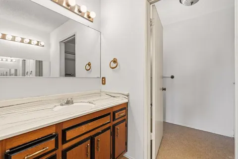 a bathroom with a granite countertop sink and a mirror