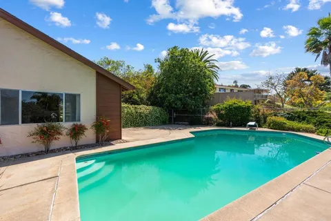 a view of a house with backyard sitting area and garden