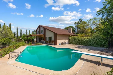 a view of a swimming pool with a yard and plants