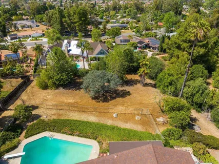 an aerial view of a house with a yard lake and outdoor seating