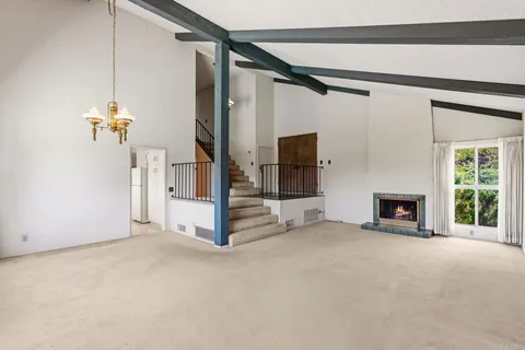 a view of a room with a fireplace cabinet and windows