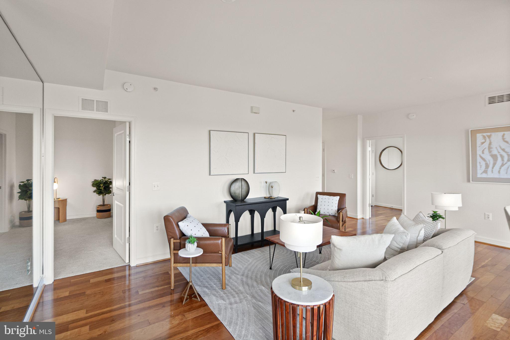 11990 Market Street, Unit 1015 Reston, VA 20190 - Photo 16 of 90 a living room with furniture a table and wooden floor