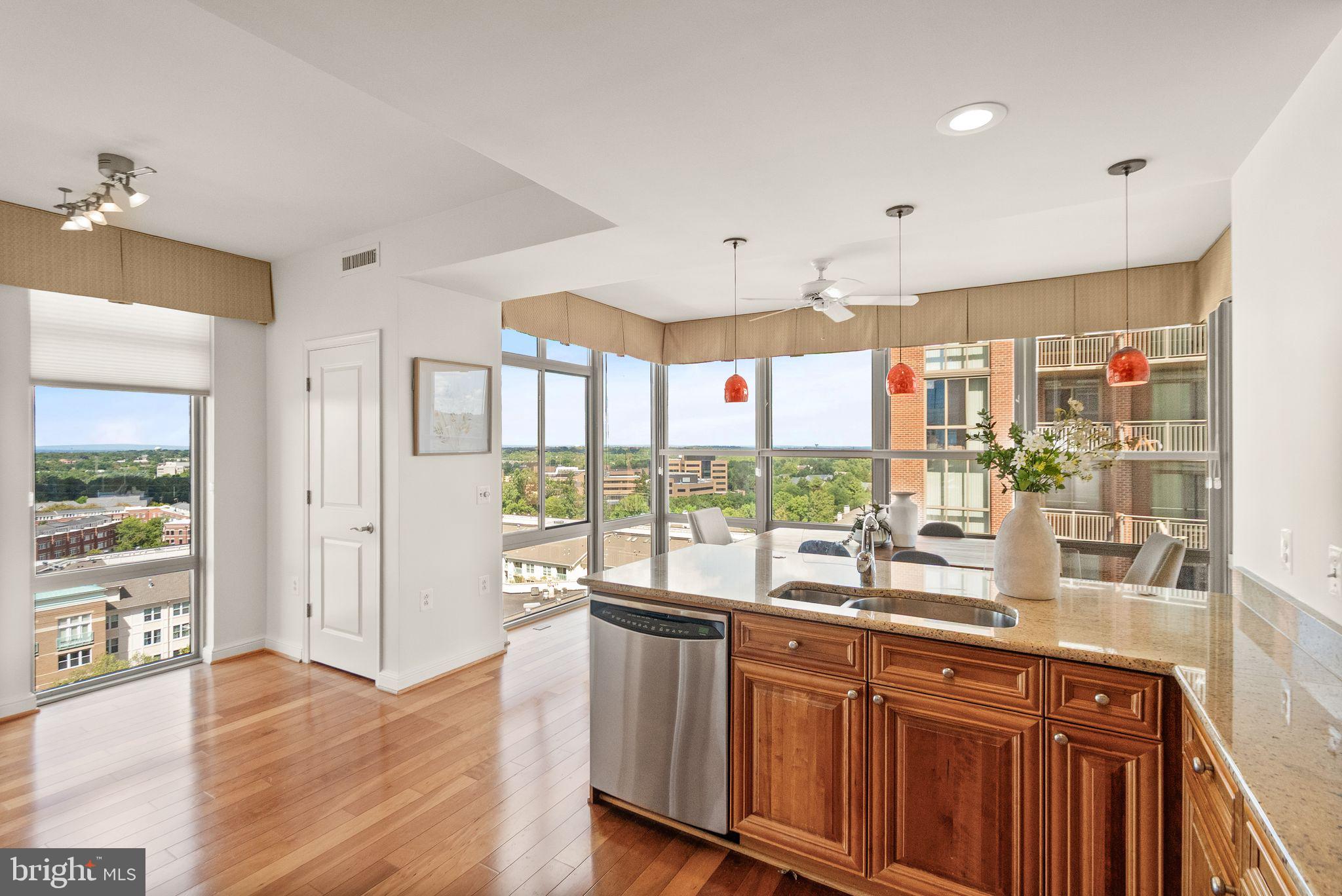 11990 Market Street, Unit 1015 Reston, VA 20190 - Photo 23 of 90 a open kitchen with granite countertop a refrigerator a sink and wooden floors