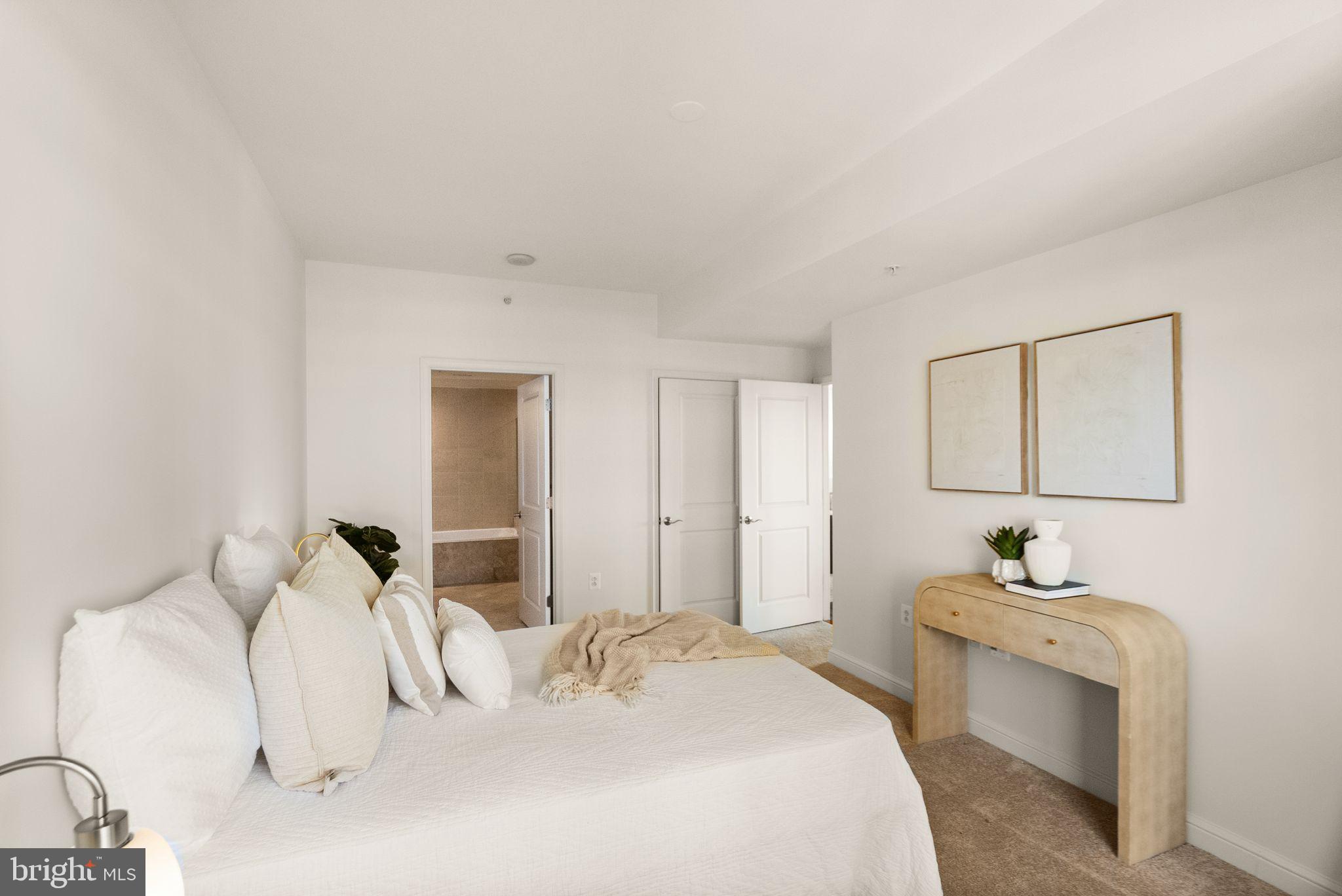 11990 Market Street, Unit 1015 Reston, VA 20190 - Photo 31 of 90 a bedroom with a white bed and a dresser