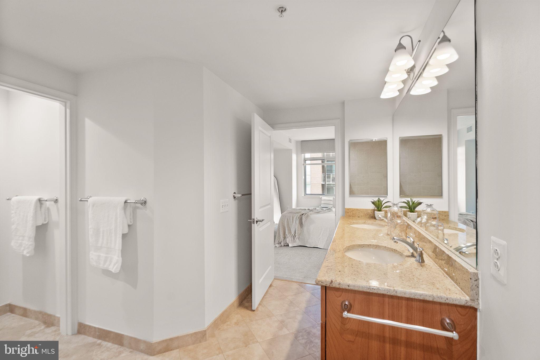 11990 Market Street, Unit 1015 Reston, VA 20190 - Photo 33 of 90 a en suite bathroom with a granite countertop sink and a mirror