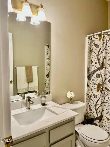 a white toilet sitting next to a shower curtain