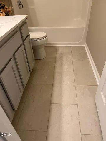 a view of an empty room with wooden floor and windows