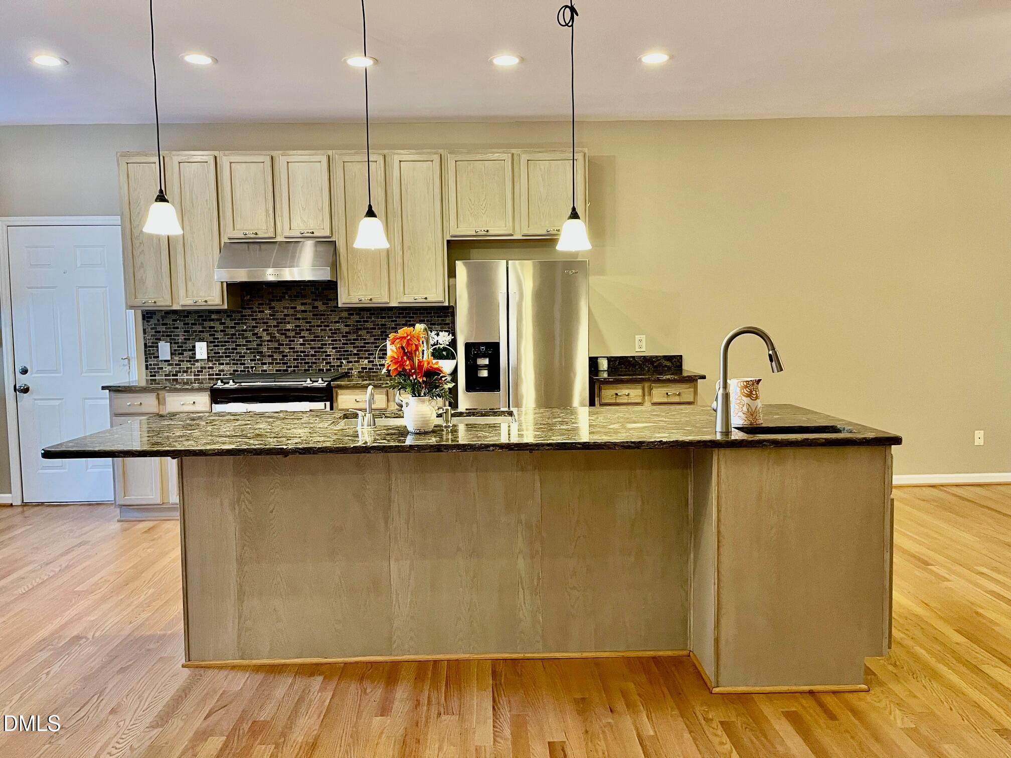 3027 Rennit Court Raleigh, NC 27603 - Photo 3 of 29 a kitchen with stainless steel appliances granite countertop a sink a stove and a wooden floors
