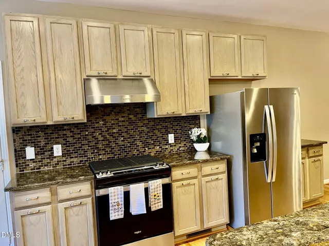 a kitchen with stainless steel appliances granite countertop a refrigerator stove and sink