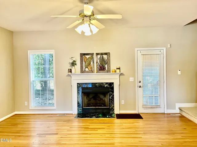 a view of a livingroom with a fireplace and window