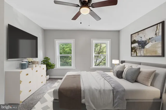 an empty room with windows and fan