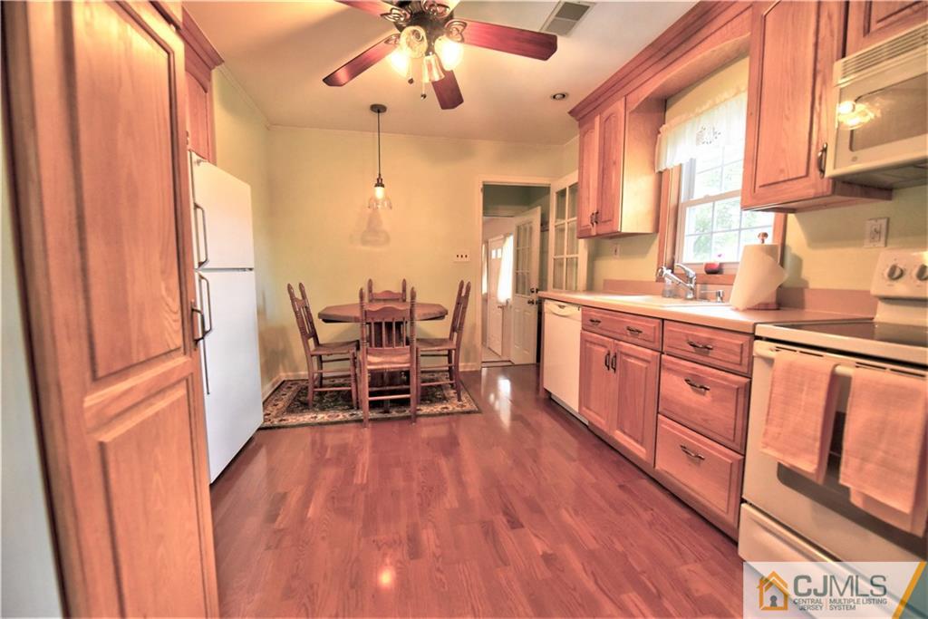 15 Burnham Road East Brunswick, NJ 08816 - Photo 6 of 16 a dining room with stainless steel appliances a dining table wooden floor and a window