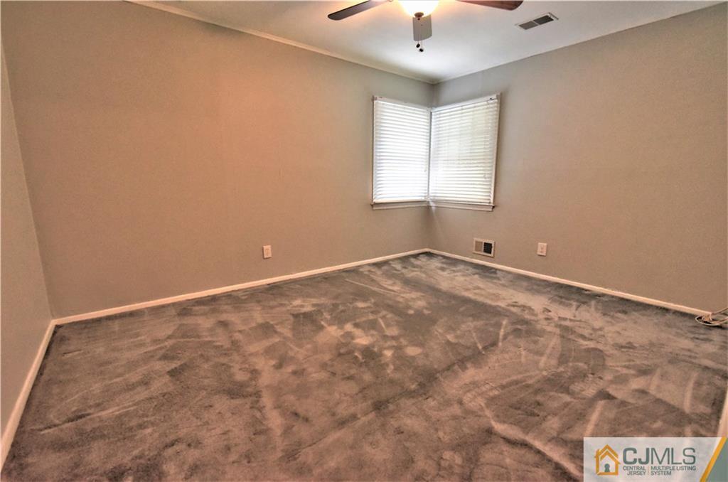 15 Burnham Road East Brunswick, NJ 08816 - Photo 9 of 16 an empty room with windows and chandelier fan
