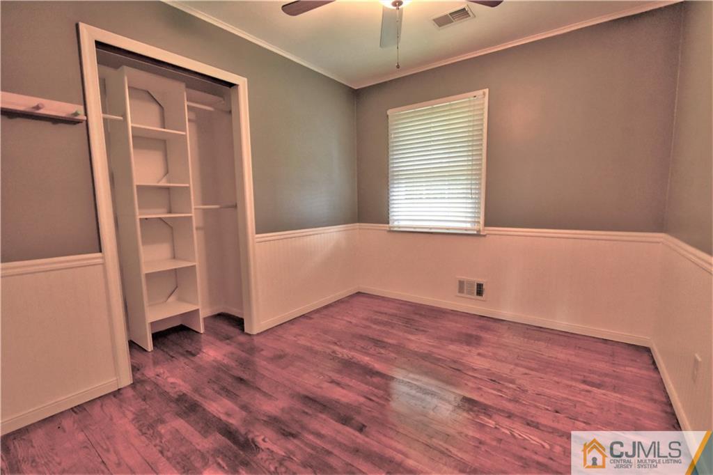15 Burnham Road East Brunswick, NJ 08816 - Photo 10 of 16 an empty room with wooden floor cabinet and windows