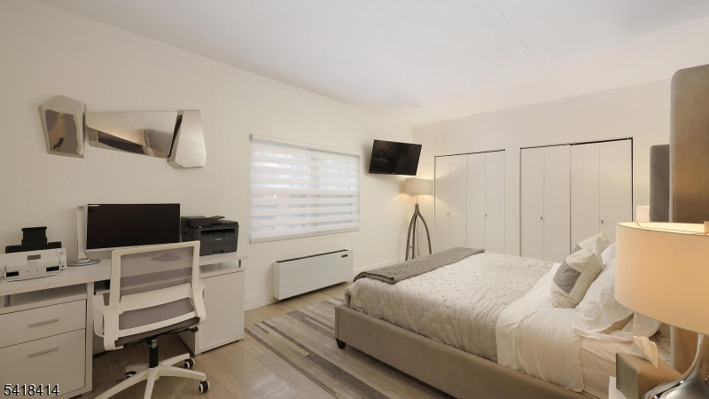 22 Riverside Drive, Unit B 7 Cranford, NJ 07016 - Photo 2 of 24 a bedroom with a bed and a flat screen tv