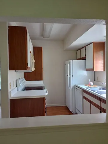 a kitchen with stainless steel appliances granite countertop a refrigerator a sink and a stove