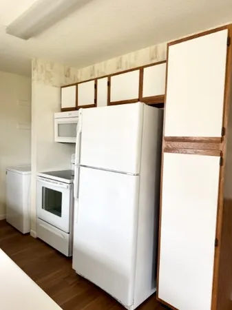 a white refrigerator freezer and a stove sitting inside of a kitchen