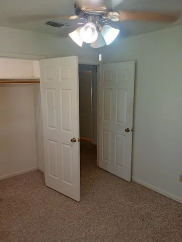 a view of a chandelier fan and closet in a room