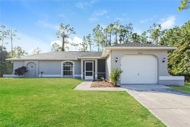 a view of a house with a yard and potted plants