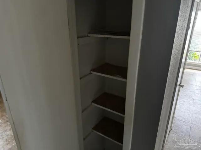 an empty room with closet and a bathroom