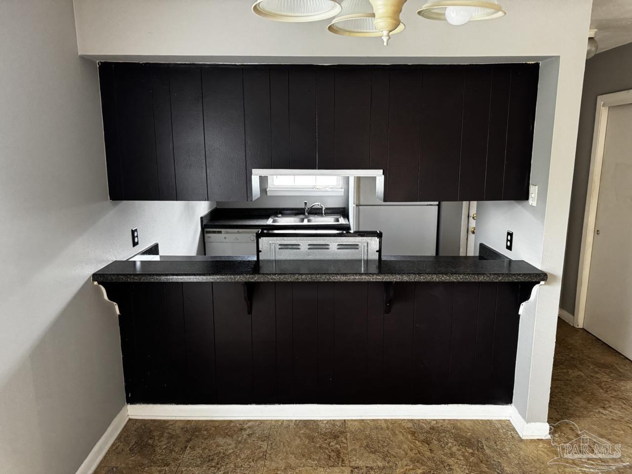 1460 Bakalane Court, Unit A Pensacola, FL 32504 - Photo 2 of 24 a kitchen with a sink and cabinets