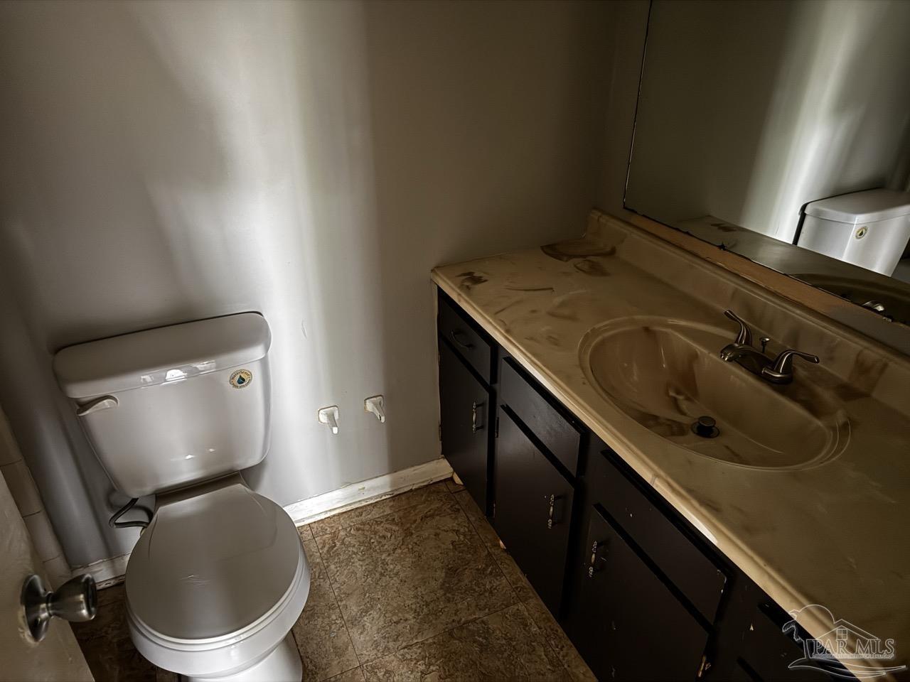 1460 Bakalane Court, Unit A Pensacola, FL 32504 - Photo 21 of 24 a bathroom with a granite countertop sink a toilet and a mirror