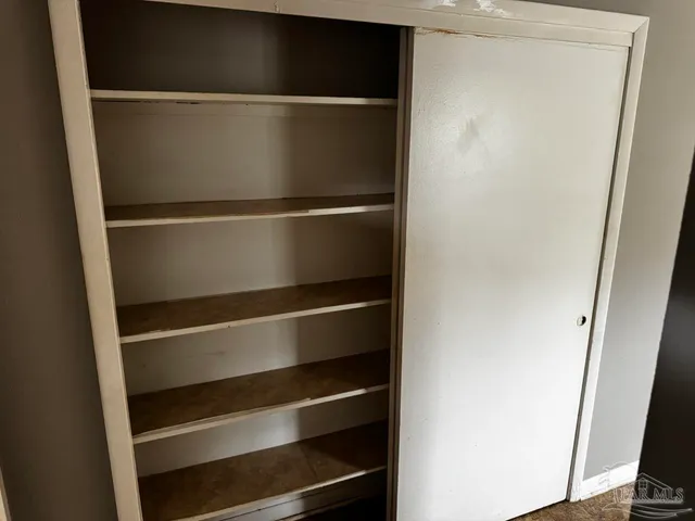 a view of walk in closet with empty racks