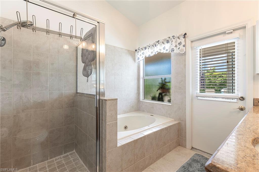 6769 Berwick Place Naples, FL 34104 - Photo 11 of 21 a bathroom with a bathtub and a shower