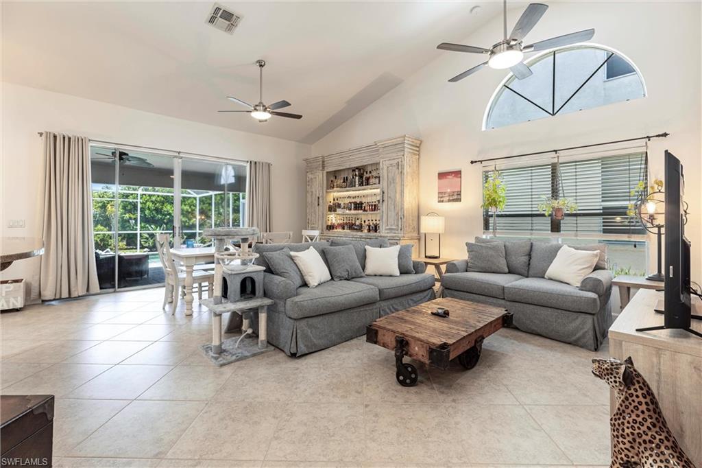 6769 Berwick Place Naples, FL 34104 - Photo 2 of 21 a living room with furniture and a chandelier