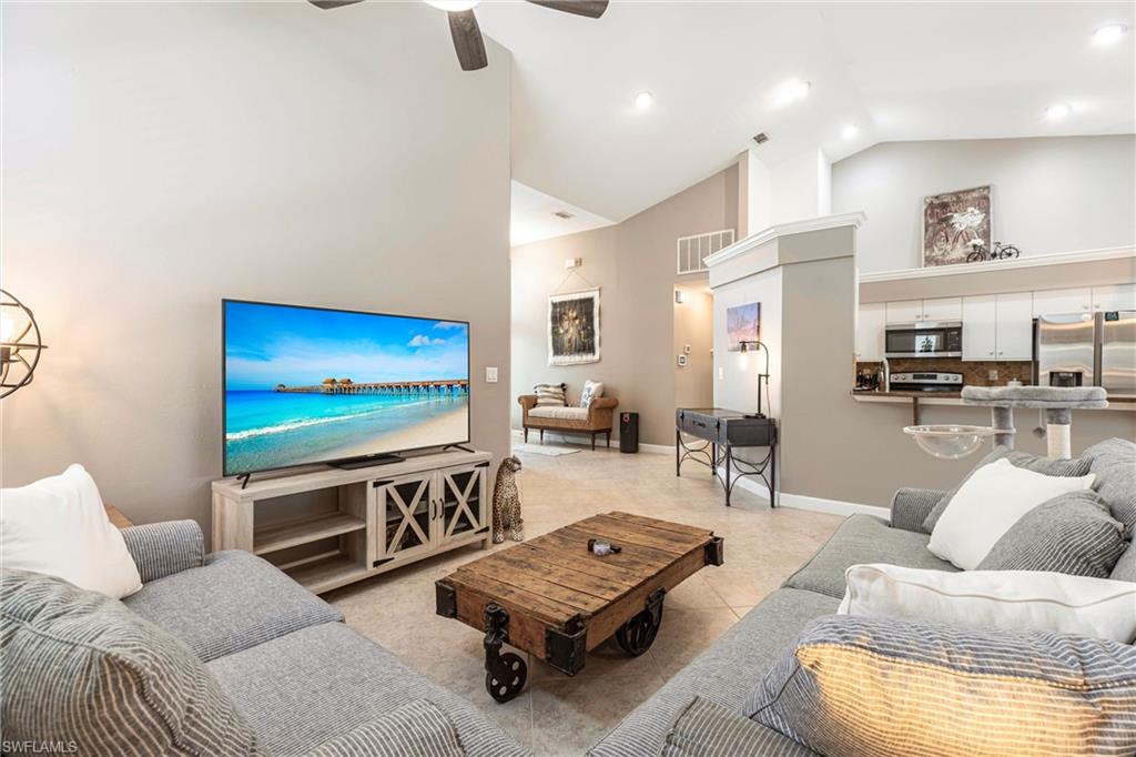 6769 Berwick Place Naples, FL 34104 - Photo 3 of 21 a living room with furniture and a flat screen tv