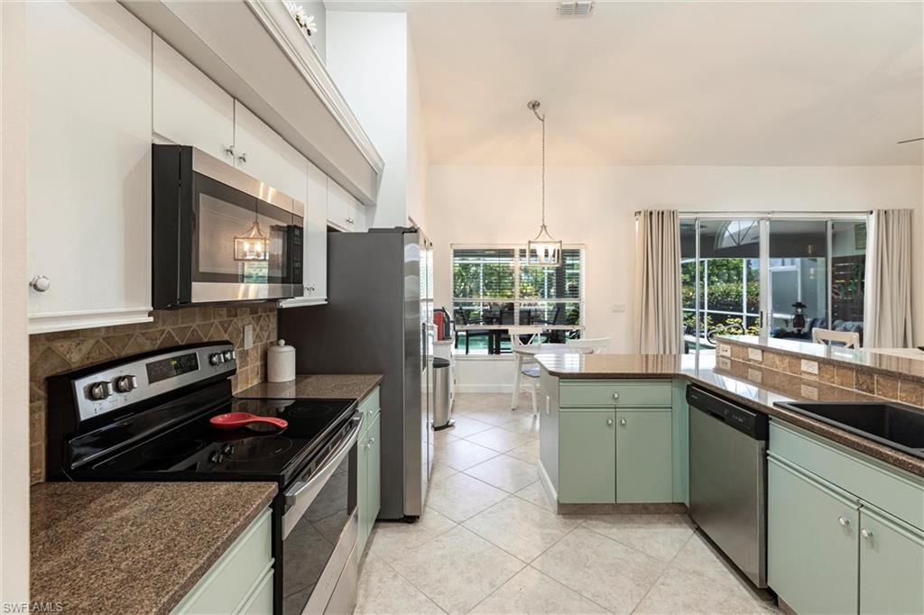 6769 Berwick Place Naples, FL 34104 - Photo 4 of 21 a kitchen with stainless steel appliances granite countertop a sink stove and refrigerator