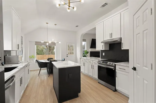 a kitchen with stainless steel appliances granite countertop a sink stove and refrigerator
