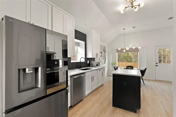 a kitchen with granite countertop a sink appliances and cabinets