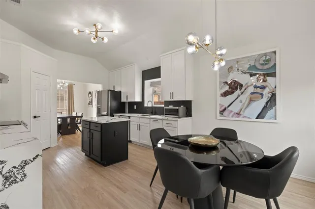 a view of a dining room with furniture and chandelier